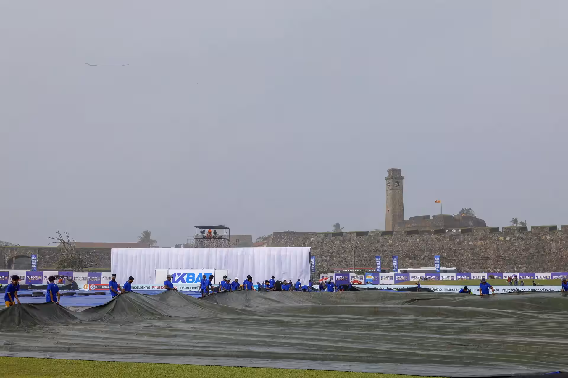 Galle [Sri Lanka], Aug 15 (ANI): Ground staff cover the ground as it rains durin...
